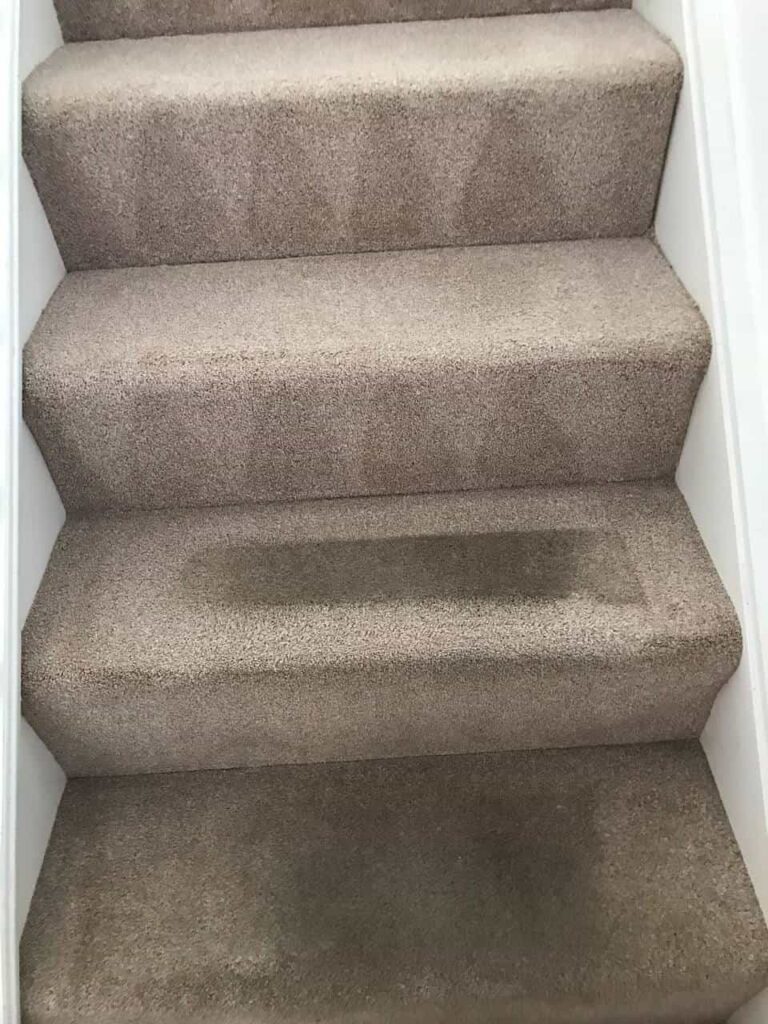 this is a photo of a staircase with beige carpets that is in the process of being cleaned works carried out by Chigwell Carpet Cleaning