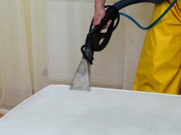 This is a photo of a man steam cleaning a dirty mattress works carried out by Chigwell Carpet Cleaning