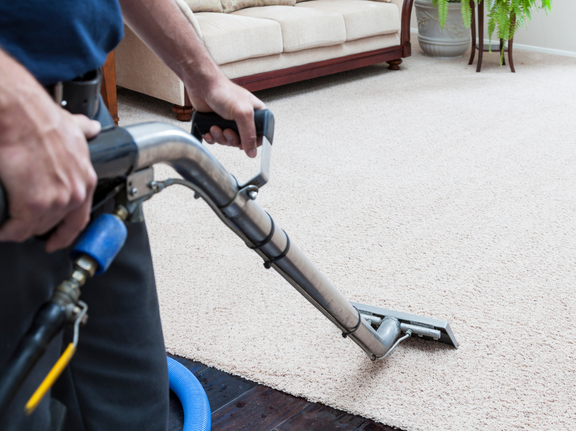 This is a photo of a man with a steam cleaner cleaning a cream carpet works carried out by Chigwell Carpet Cleaning